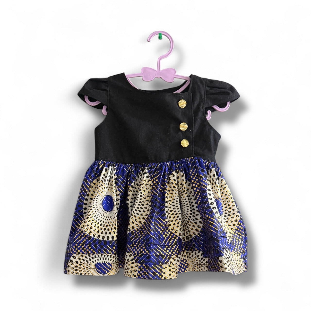 Zoewandi dress on hanger, handmade African print dress with gold buttons and cap sleeves by Young World by Ruth.