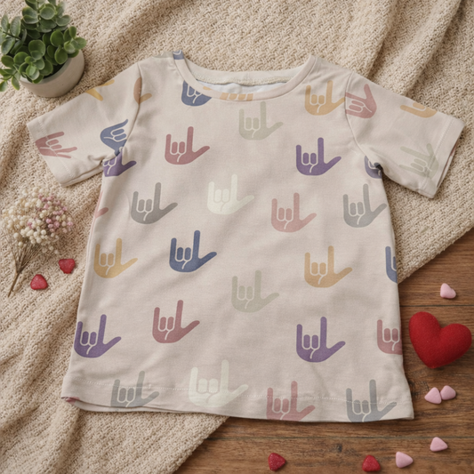 Gender-neutral children’s graphic T-shirt featuring an inclusive hand-sign design on a soft neutral cotton tee